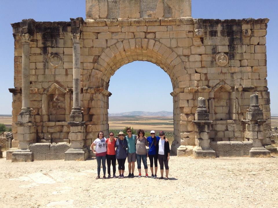 Students taking a group picture in front of ancient building.