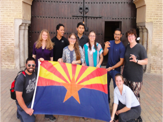 Arizona Flagship students posing with an Arizona state flag.