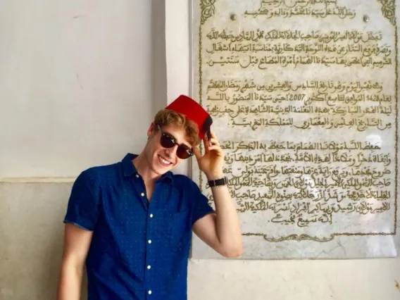 Student in front of Arabic sign in Fes