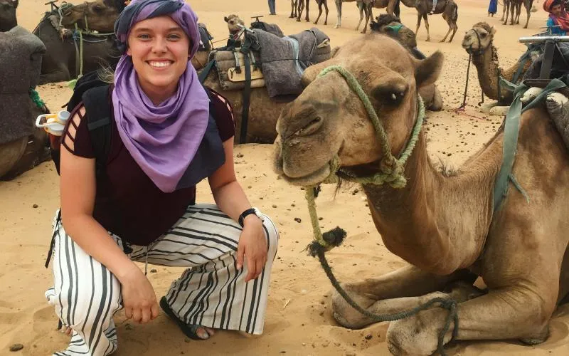 Project GO student taking a picture with a camel.